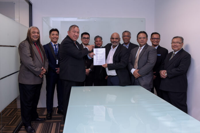 Ahmad Sufiani (third left) exchange document with Mohamed Yunus after the signing of MoU in Kuala Lumpur today.